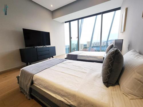 een slaapkamer met 2 bedden en een flatscreen-tv bij Luxury Condo Paradox Santa Fe By Bamboo Skylife in Mexico-Stad