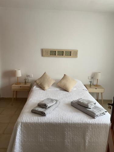uma cama branca com duas toalhas em cima em Las Margaritas Binibeca Menorca em Binibeca