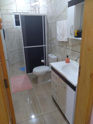 a bathroom with a toilet and a sink and a shower at Pousada 4 estações in Machadinho