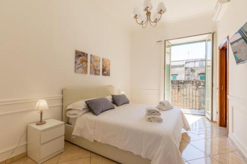 Habitación blanca con cama y ventana en Montesanto Family, en Nápoles