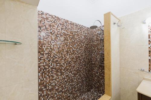 y baño con ducha de azulejos marrones. en Montesanto Family, en Nápoles