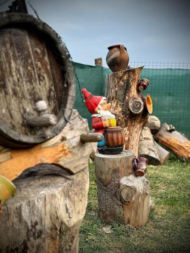 a bird statue sitting on top of a wooden stump at Cabanutele La Denisa in Dubova