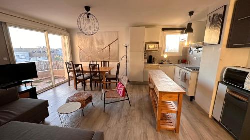 un salon avec une cuisine et une salle à manger dans l'établissement Appartement de l'oursinière 4/6 pers vue mer, à Palavas-les-Flots