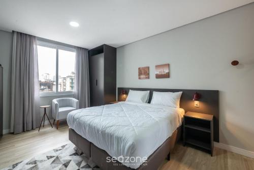 a bedroom with a large bed and a window at TCO - Apartamentos no Centro Histórico Porto Alegre/RS in Porto Alegre