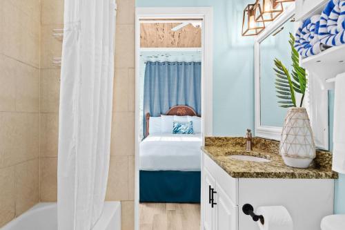 a bathroom with a bed and a tub and a sink at Parrot Beach Cottages Suite #2 in Siesta Key