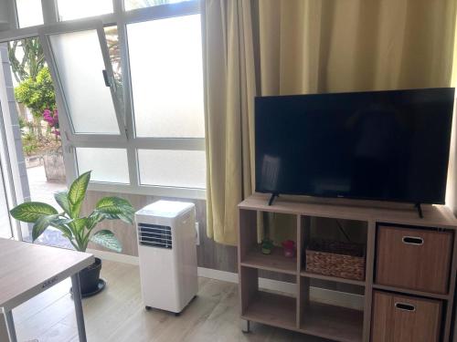 a living room with a flat screen tv on a entertainment center at Relax apartamento 7 in Las Palmas de Gran Canaria