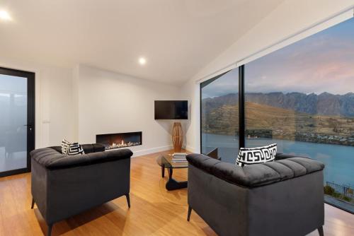a living room with two chairs and a fireplace at No.8 Queenstown in Queenstown