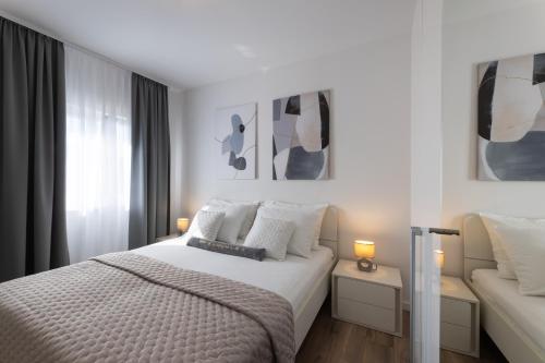 Habitación blanca con cama y sofá en Apartment Tinel, en Trogir