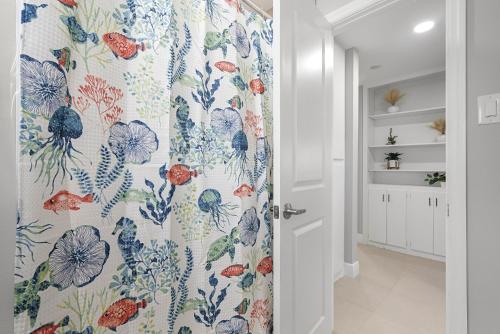 a bathroom with a shower curtain with a floral pattern at 3/2 Close to Beach Pet Friendly in Fort Pierce