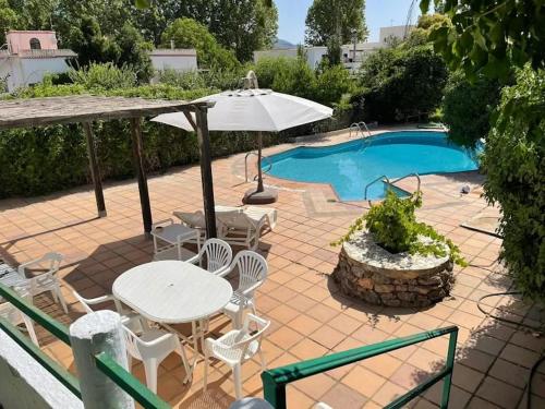 a patio with a table and chairs and a pool at Villa Fuente Victoria in Fuente Victoria