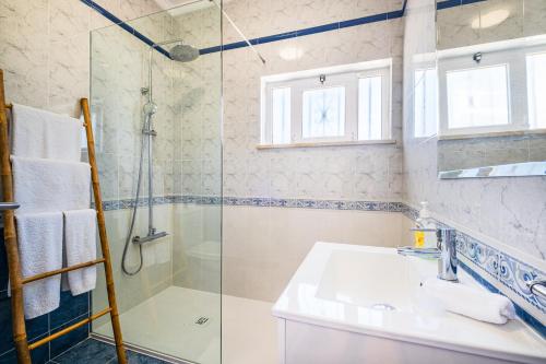 uma casa de banho com uma cabina de duche em vidro e um lavatório. em Vicente Mar Luxury Villa - Free WiFi em Albufeira