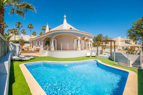 a villa with a swimming pool in front of a house at Vicente Mar Luxury Villa - Private Pool in Albufeira
