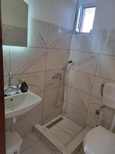 a bathroom with a shower and a sink and a toilet at STUDIOS MONA in Agios Georgios