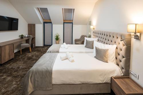 um quarto de hotel com duas camas e uma televisão em ALIVE HOTEL em Oradea
