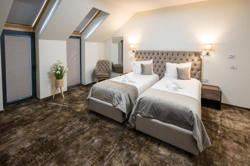 a hotel room with two beds and a chair at ALIVE HOTEL in Oradea