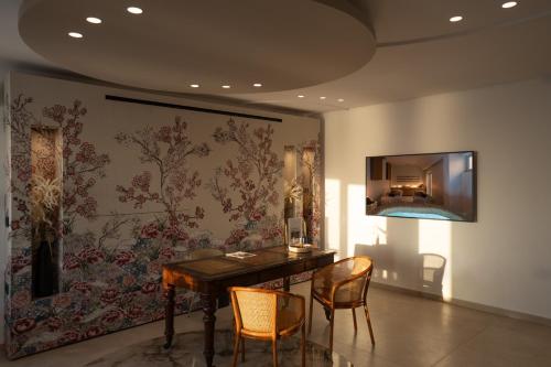 a dining room with a table and chairs and a wall at Volcano View by Caldera Collection in Fira