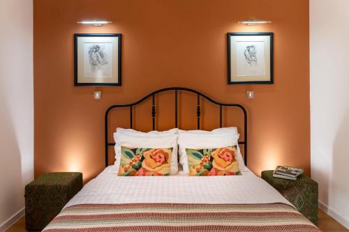 a bedroom with a bed with orange walls at Classy & Central Apartment David (parking included) in Virpazar