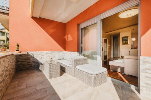 a patio with wicker furniture and orange walls at Apartment KIM in Umag