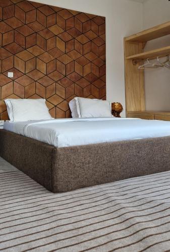 Cama grande en habitación con pared en Appartements meuble SEED, en Yaoundé
