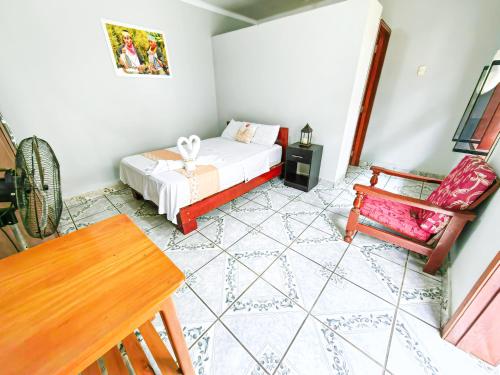 1 dormitorio con 1 cama, 1 silla y 1 mesa en Tengana Hospedaje y Tours, en Tarapoto