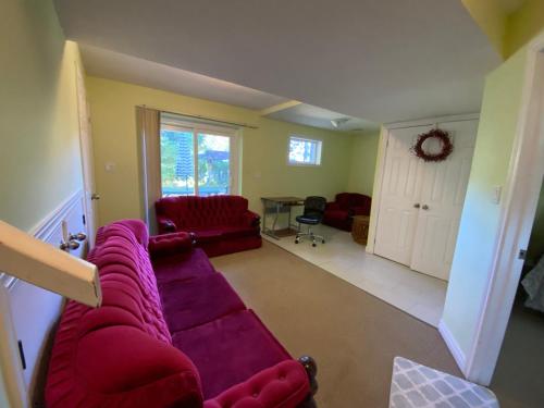 sala de estar con sofá rojo y mesa en HB GUEST HOME 6, en Waterloo