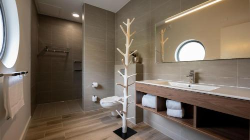 a bathroom with a sink and a toilet and a mirror at The Beach House in Willemstad