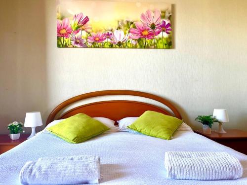 een bed met twee kussens en een schilderij aan de muur bij Comfort living apartment in Orbassano