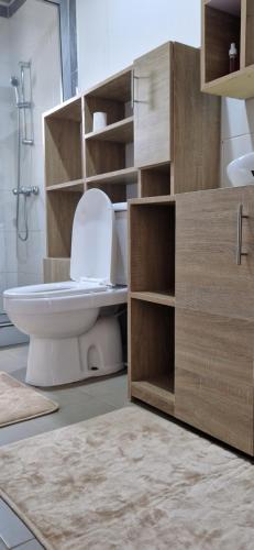 Un baño con inodoro blanco y ducha. en Appartements meuble SEED, en Yaoundé