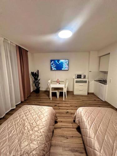 E&K Apartment II في دوسلدورف: غرفة نوم بسريرين وطاولة وتلفزيون