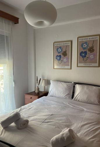 a bedroom with a large white bed with a light fixture at Varosi Apartment in Komotini