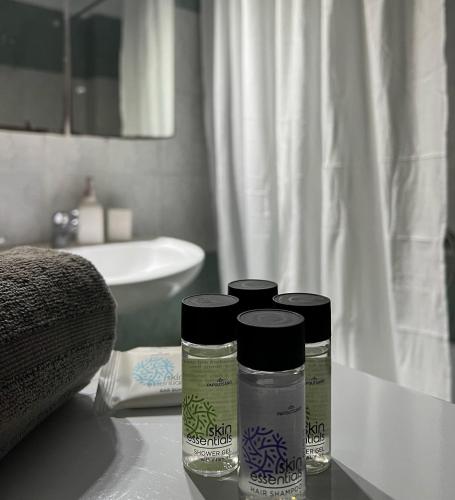 three bottles sitting on a counter in a bathroom at Varosi Apartment in Komotini