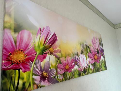 ein Gemälde rosa Blumen an der Wand in der Unterkunft Comfort living apartment in Orbassano