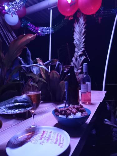 Amour Sea Side في كوروتوغو: طاولة مع طبق من الطعام وزجاجة من النبيذ