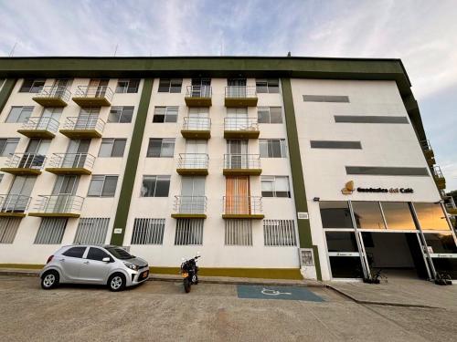 un bâtiment avec une voiture garée devant lui dans l'établissement Apartamento totalmente equipado a 5 minutos del Parque del Café - Montenegro, à Montenegro