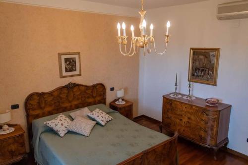 - une chambre avec un lit et un lustre dans l'établissement Agriturismo Pino Argentato, à Bussolengo