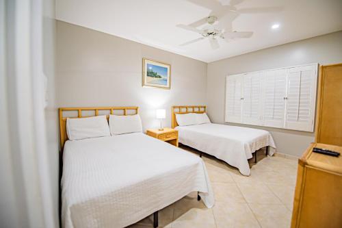 a bedroom with two beds and a window at Seven Mile Beach Resort in George Town