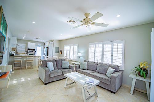 a living room with two couches and a kitchen at Seven Mile Beach Resort in George Town
