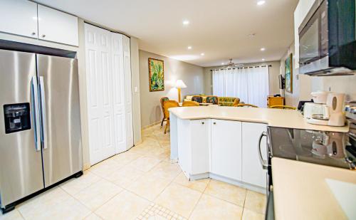 a kitchen with a refrigerator and a dining room at Seven Mile Beach Resort in George Town
