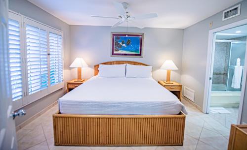 a bedroom with a large bed and two lamps at Seven Mile Beach Resort in George Town