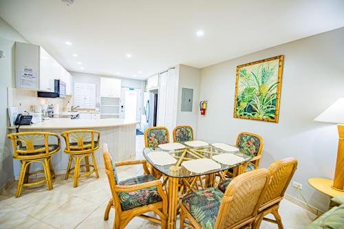 a dining room with a table and chairs and a kitchen at Seven Mile Beach Resort in George Town