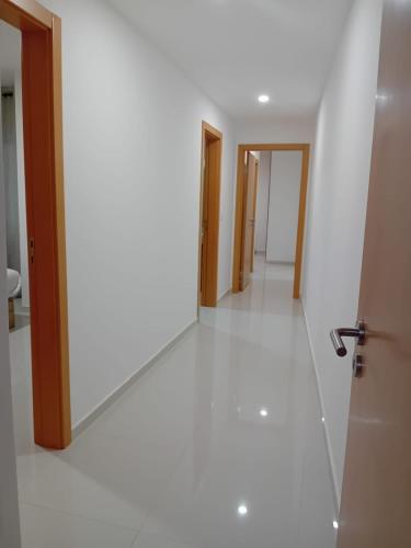 einen Flur mit weißen Wänden und einer Tür und einem Zimmer in der Unterkunft Residencia Vieira in Praia