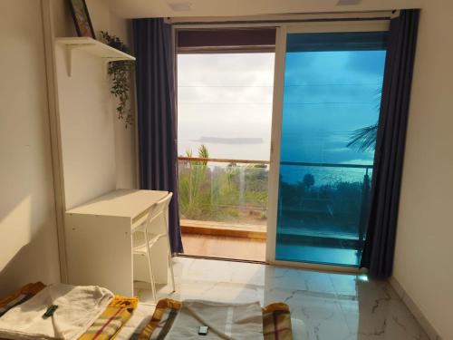 a room with a large window with a view at Dhayra's Seascape homestay at Dapoli in Ānjarle