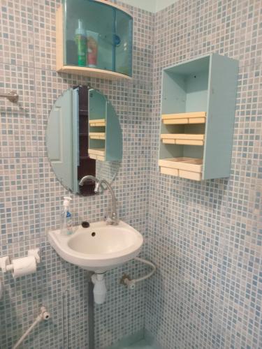 een badkamer met een wastafel en een spiegel bij Sue's Place in Paramaribo