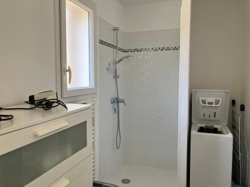une salle de bain avec une douche avec une porte vitrée dans l'établissement Le p'tit mas, à Cavalaire-sur-Mer