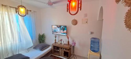 a room with a bed and a tv on a wall at Bamburi One Bedroom Apartment in Mombasa