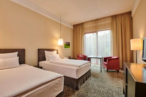 a hotel room with two beds and a table at NH Collection Prague in Prague
