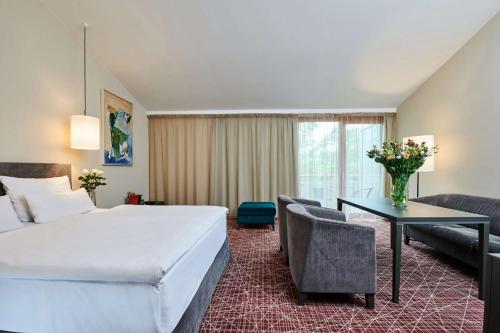 a hotel room with a large bed and a desk at NH Collection Prague in Prague
