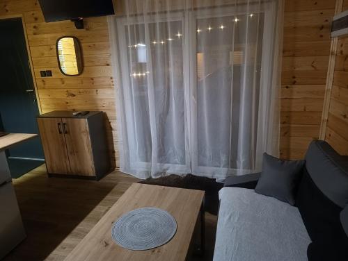 a living room with a couch and a table at Domek MODERN BARN- 4 tylko 800m od Suntago Ranczo Gold Mania in Krzyżówka