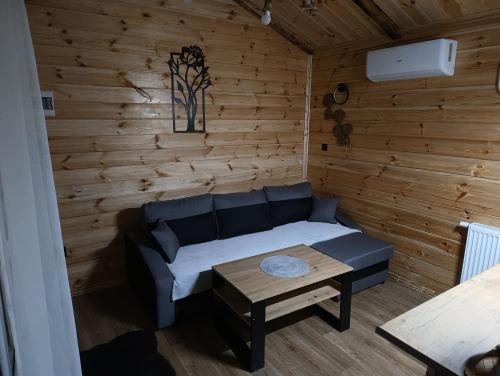 a living room with a couch and a table at Domek MODERN BARN- 4 tylko 800m od Suntago Ranczo Gold Mania in Krzyżówka