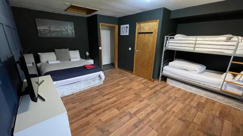 a bedroom with two bunk beds and a wooden floor at Bryn Bettws Lodge in Port Talbot